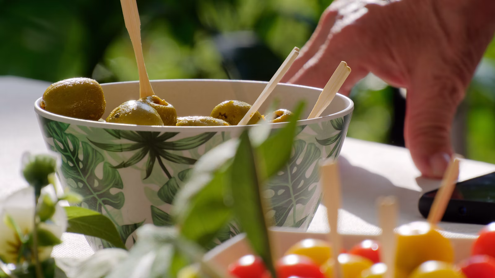 Aceitunas en un cuenco junto a verduras frescas