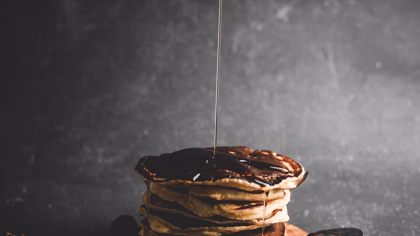 Jarabe vertido sobre una pila de hot cakes