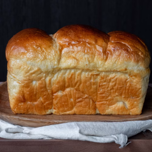 Pan brioche casero dorado sobre una mesa