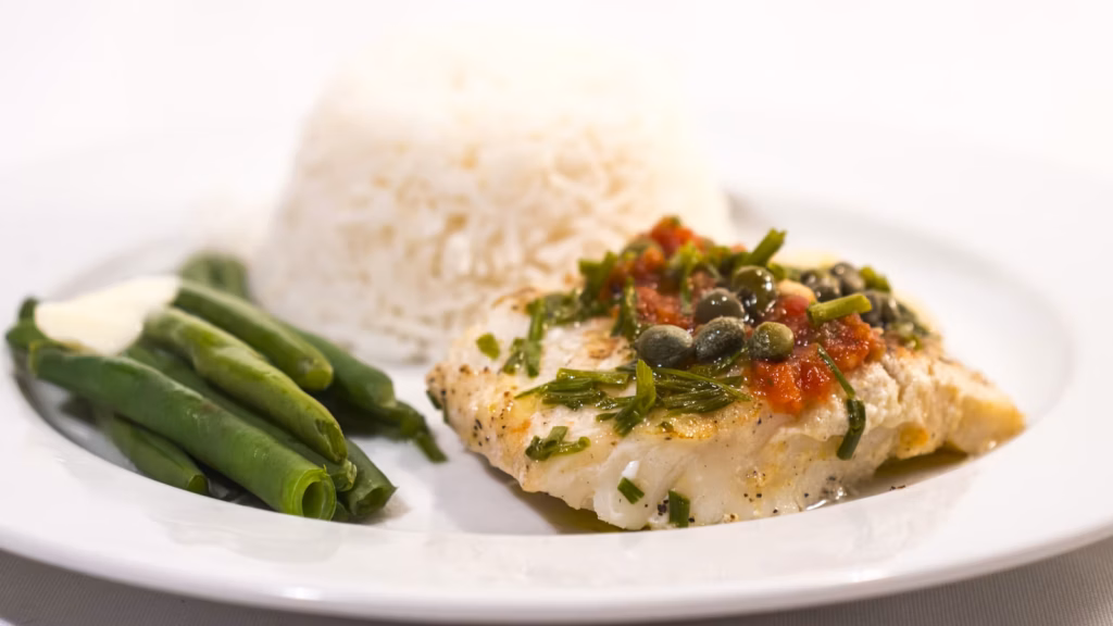 Pescado servido con alcaparras, jitomate, arroz y ejotes