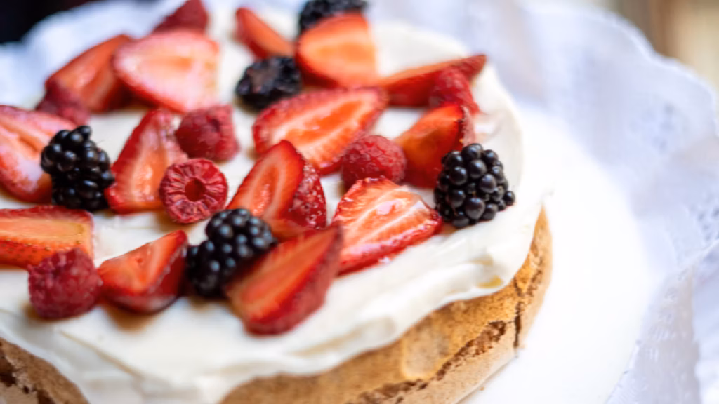 Pastel con crema blanca y fresas frescas encima
