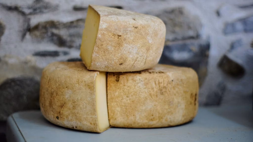 Ruedas de queso con una porción cortada