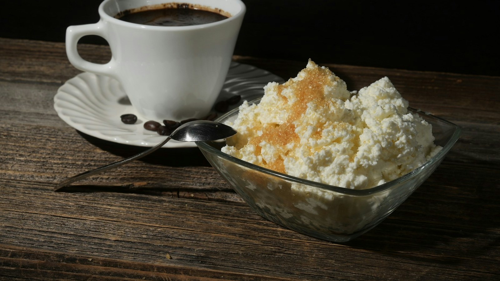 Tazón de queso cottage junto a una taza de café