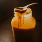 Dulce de leche casero de color caramelo en un recipiente