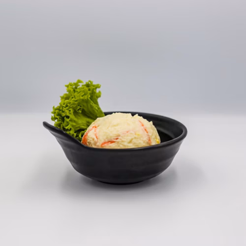 Ensalada rusa cremosa con papas y verduras servida en un plato