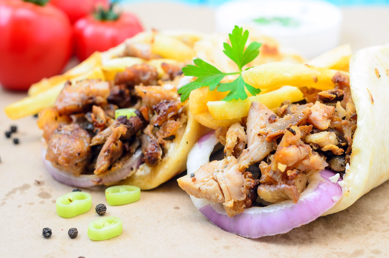 Pan pita servido con carne asada, cebolla y tomate