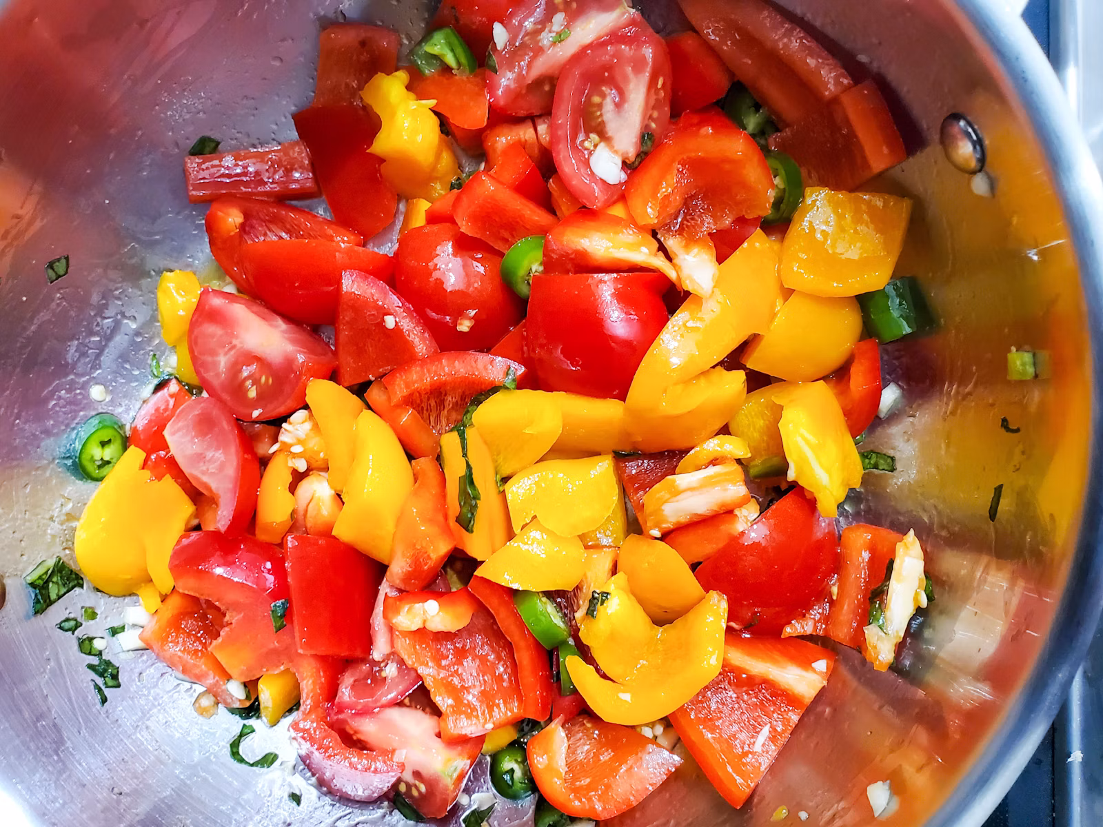 Pimientos de colores asándose para un guiso de salchicha