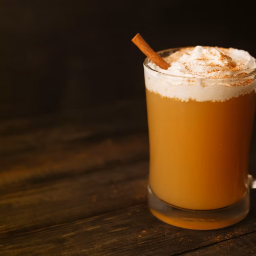 Taza de ponche navideño caliente con fruta y especias