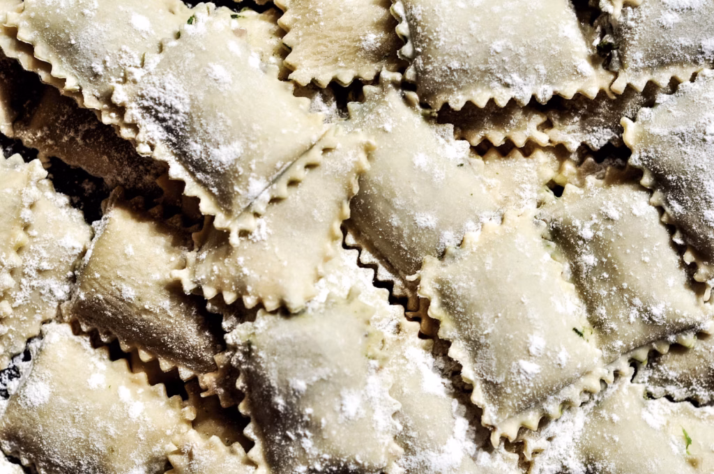 Ravioles caseros rellenos sobre una superficie enharinada