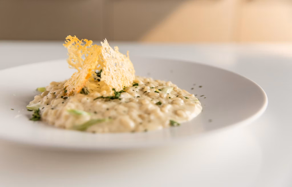 Risotto cremoso de parmesano servido en plato blanco