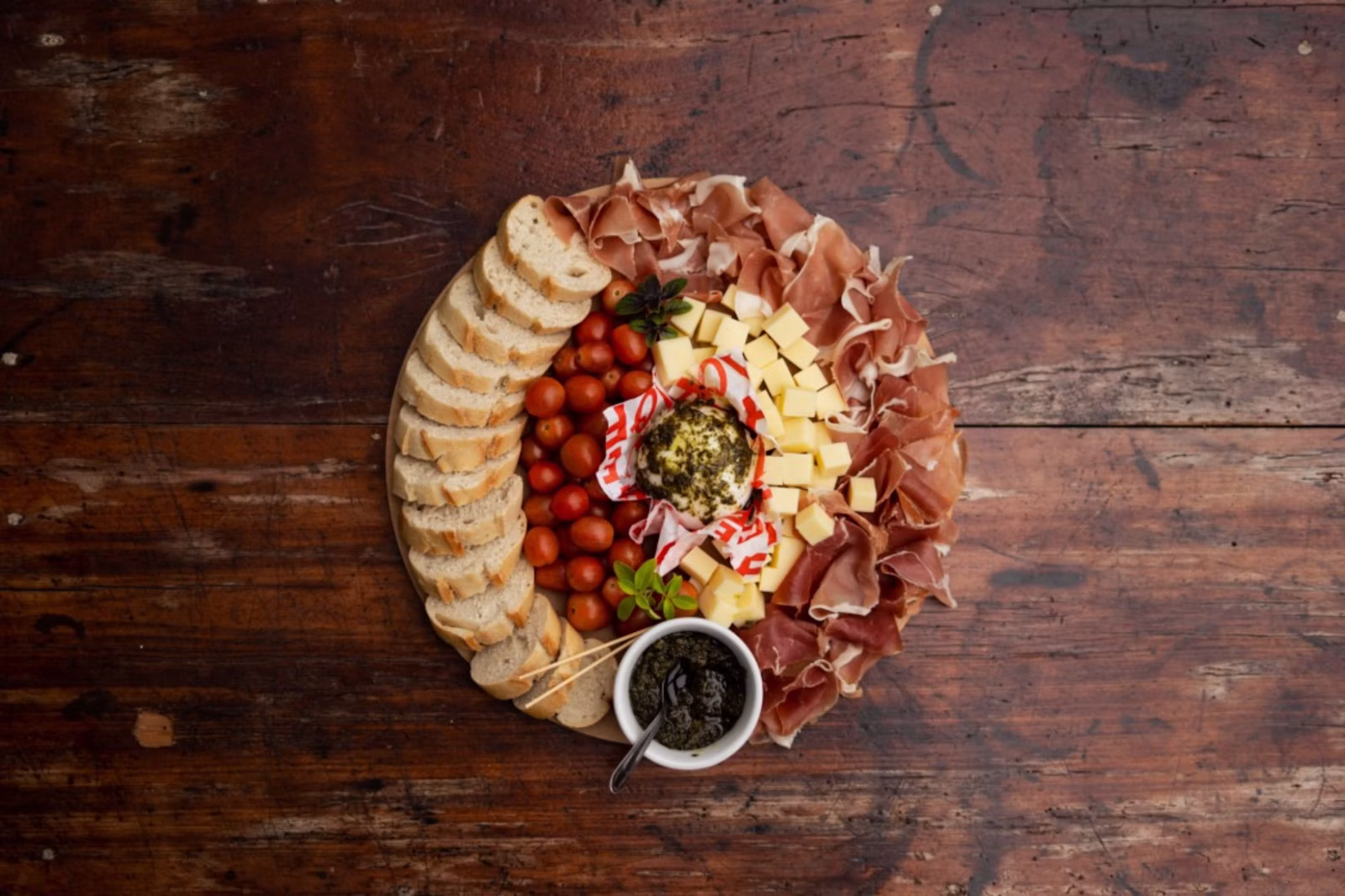 Tabla con quesos, pan, tomates y aceitunas